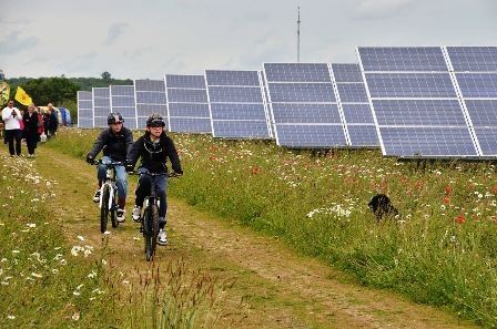 People Biking next to Solar Panels